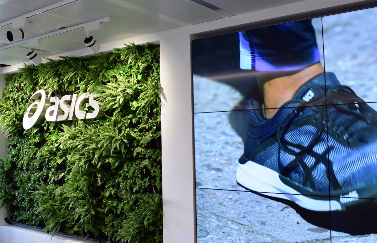 ASICS store exterior in New York City, showcasing athletic footwear and apparel in a vibrant urban setting.
