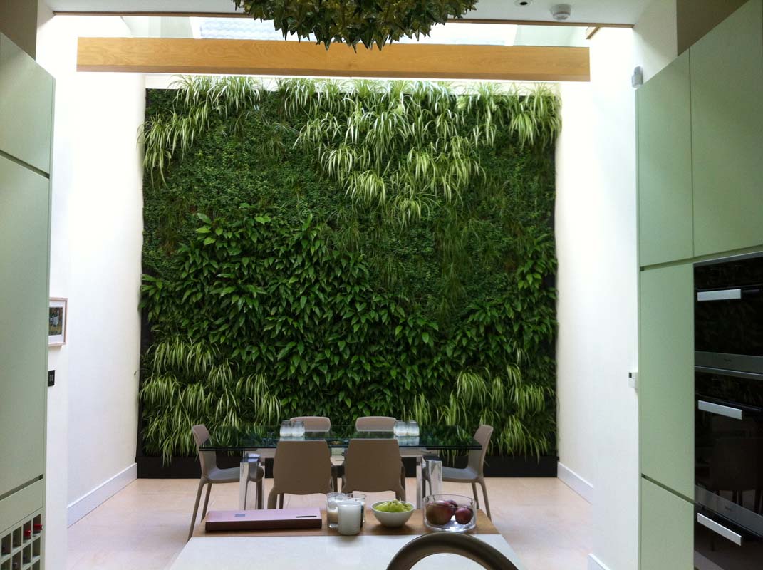 A modern lounge featuring a vibrant wall adorned with lush green plants, adding a touch of nature to the space.