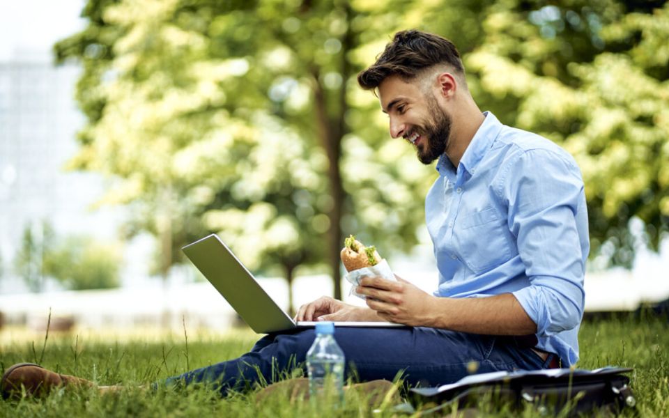 man in park with laptop