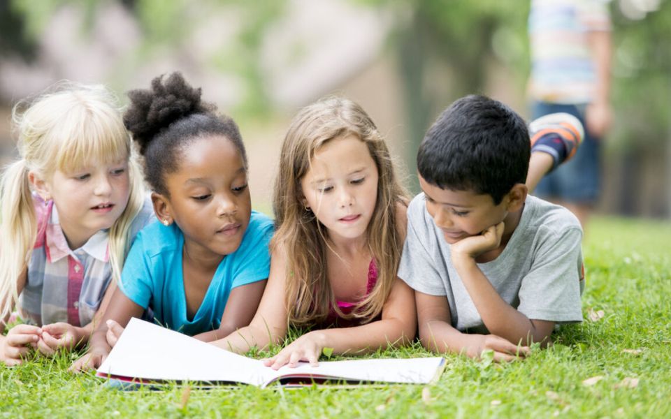 diverse children in park reading
